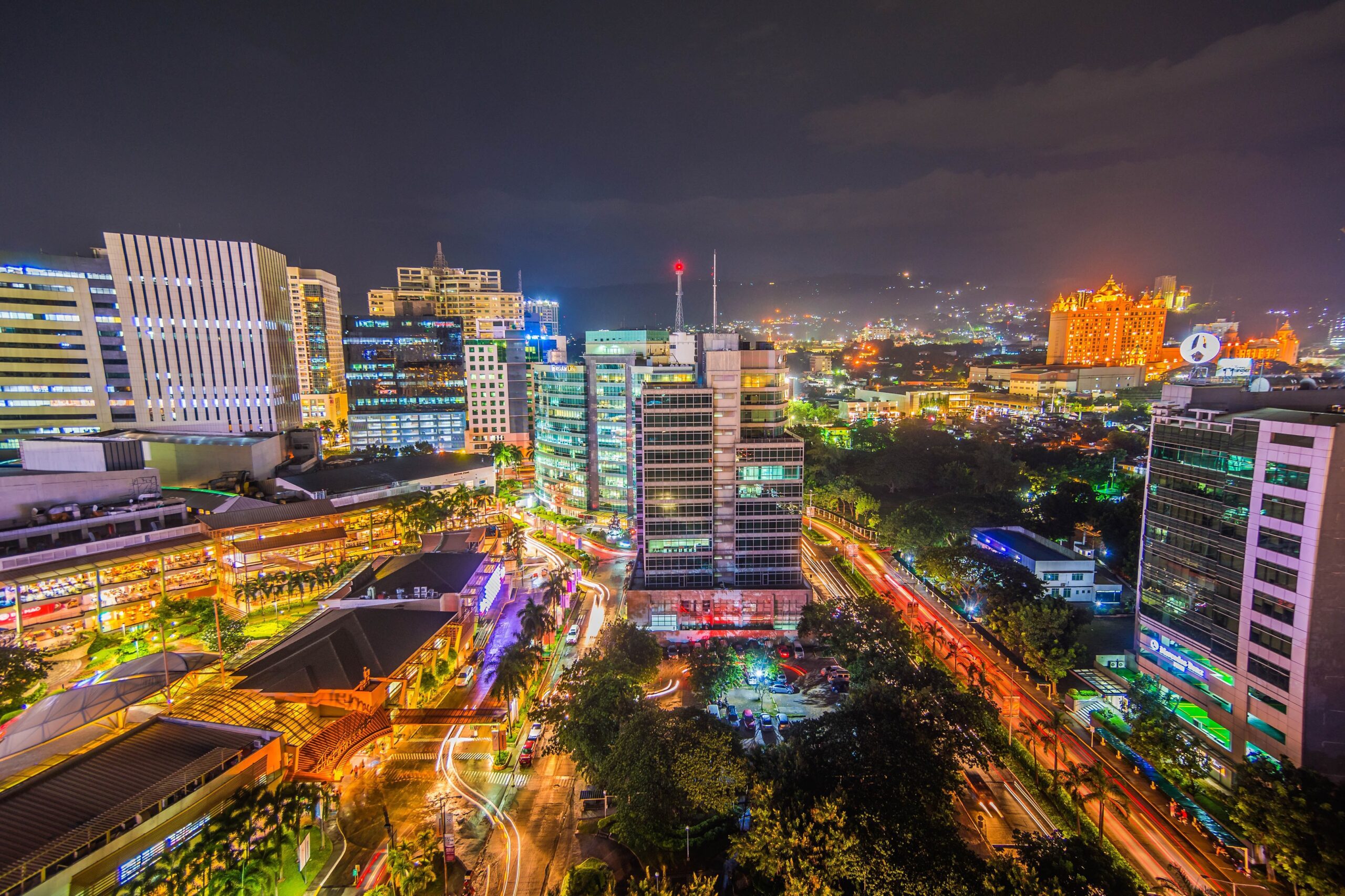 Aerial view od Cebu Business Park at night with tall buildings and colorful lights