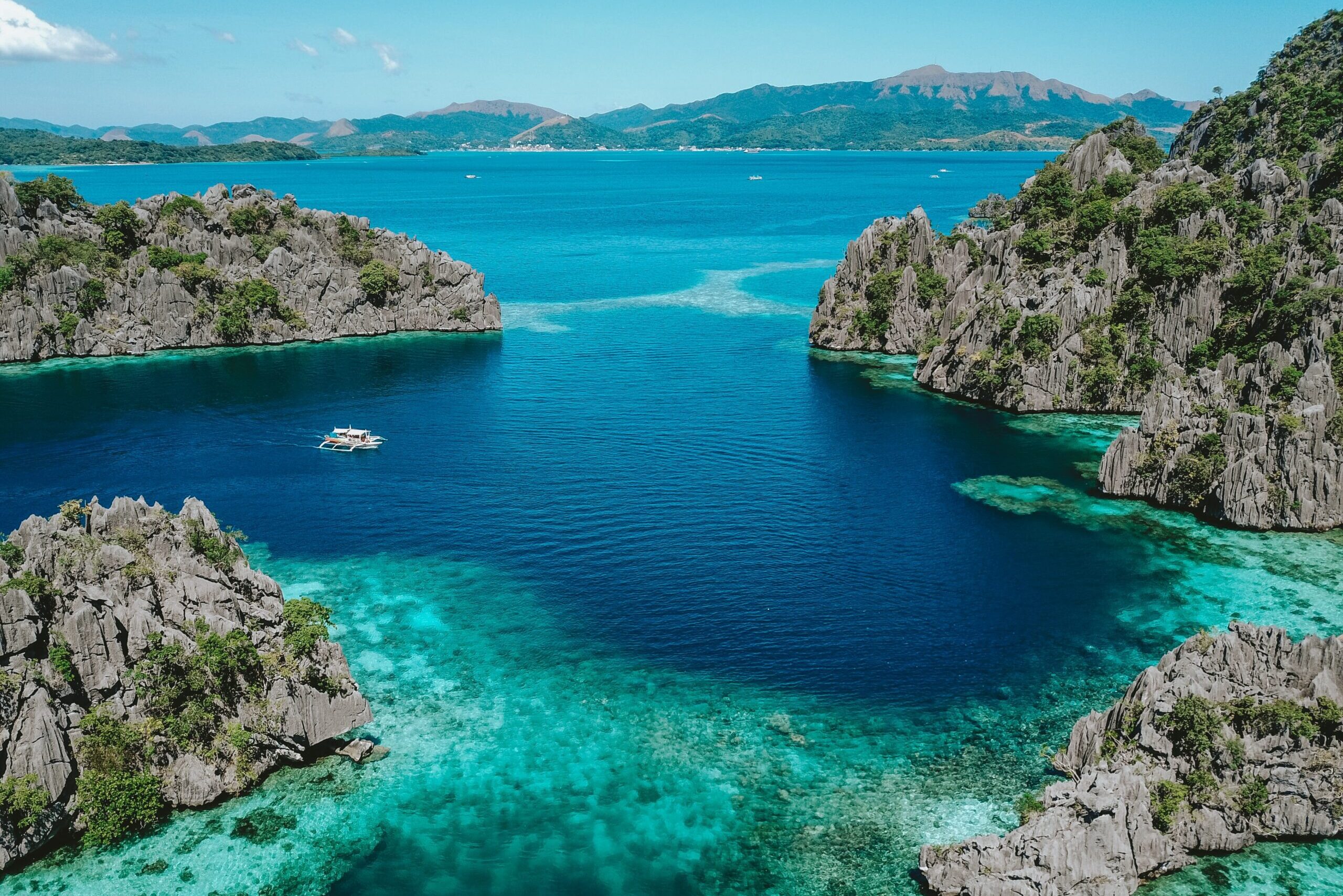 Aerial view of blue sea surrounded of limestone karsts during daytime