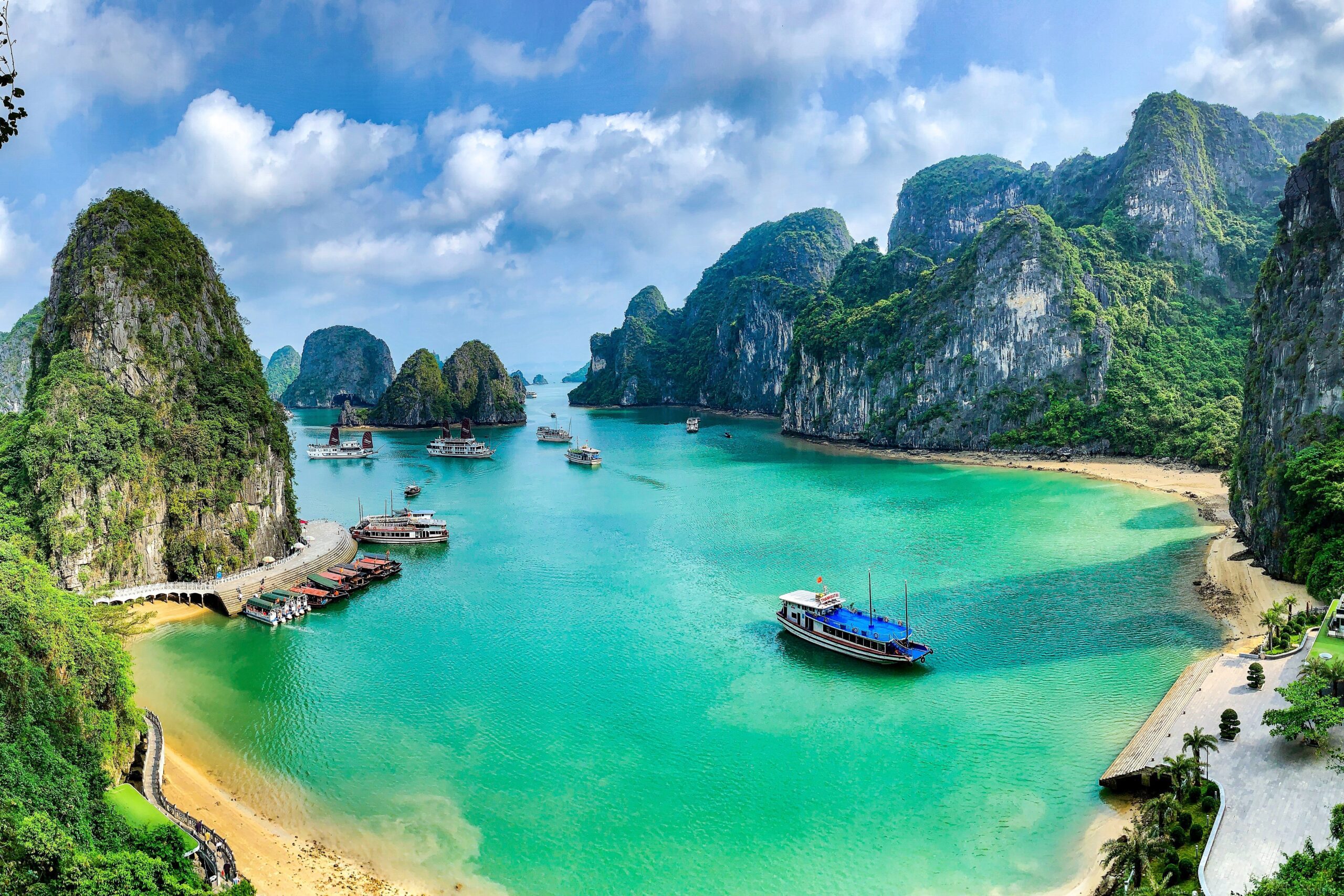 Blue lagoon with ships surrounded by limestone mountains