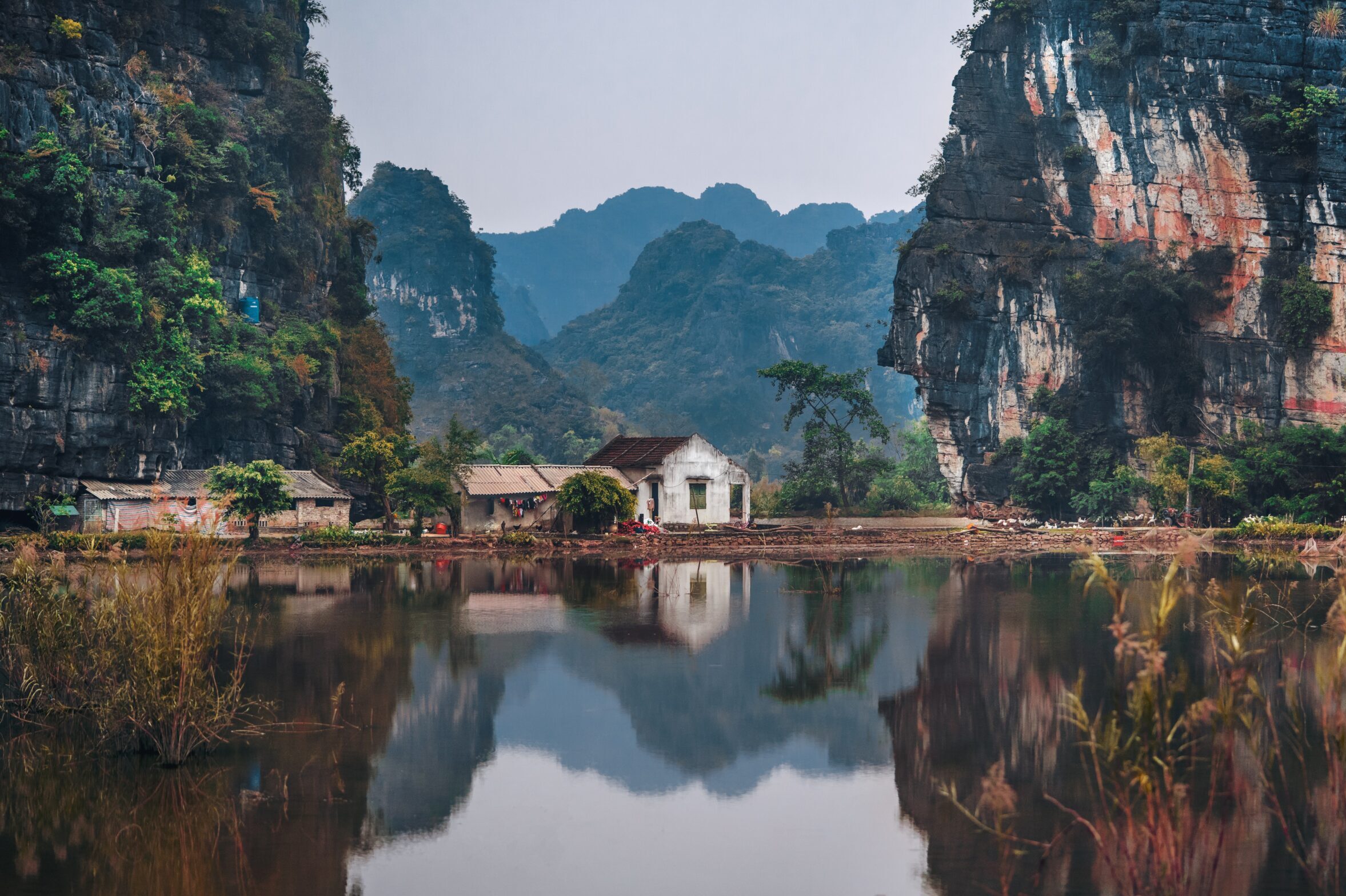 Old house on a lake mirroring the surrounding limestone mountains