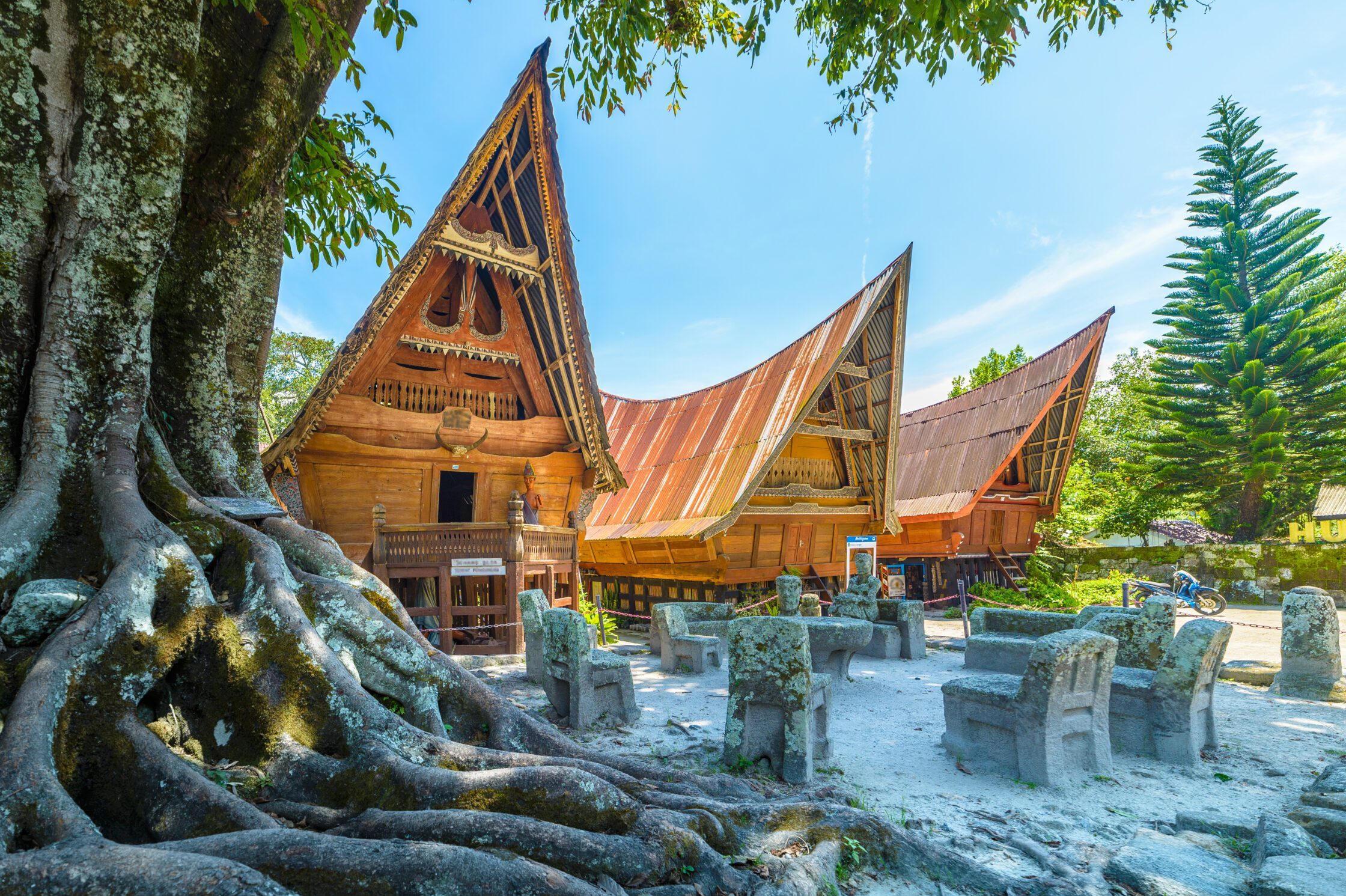 Three traditional Batak Toba houses with steeply rising roof with eaves