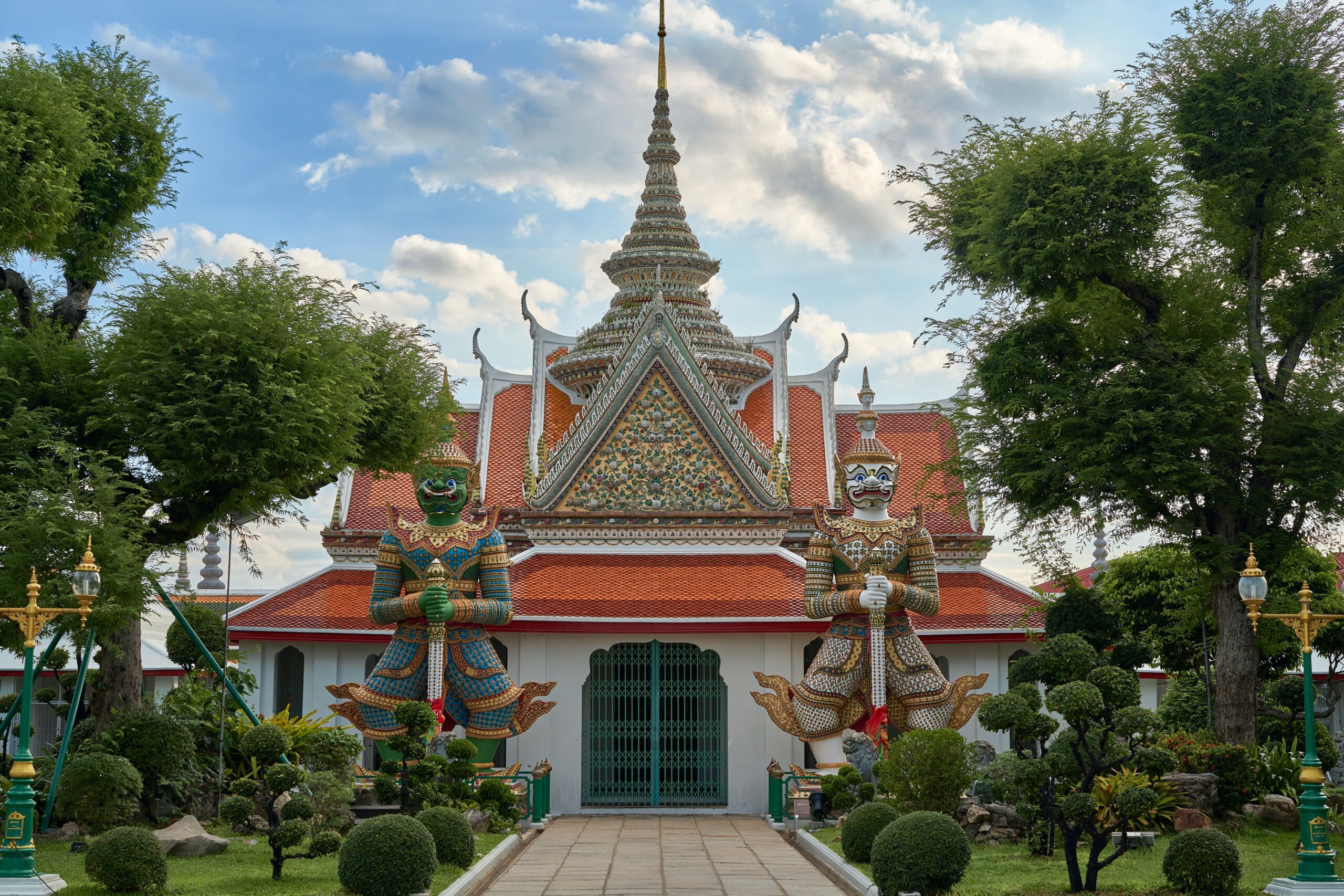 Thai Buddhist temple with intricate roof and two guardian statues