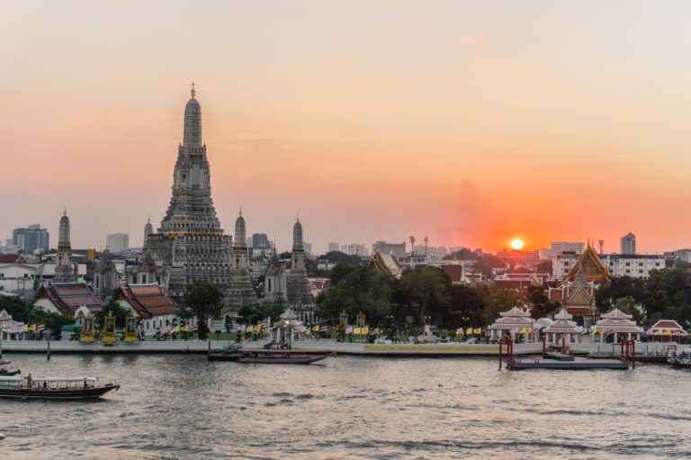 Thai Buddhist temple next to the river at sunset