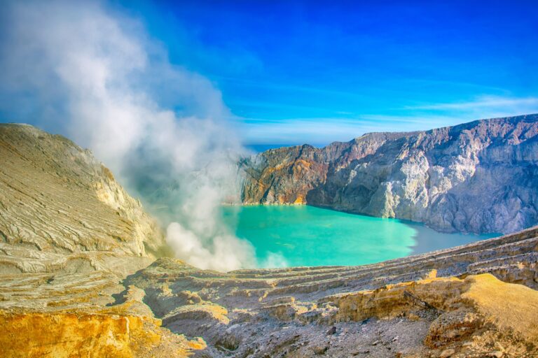 Ijen volcano crater with lake and smoke